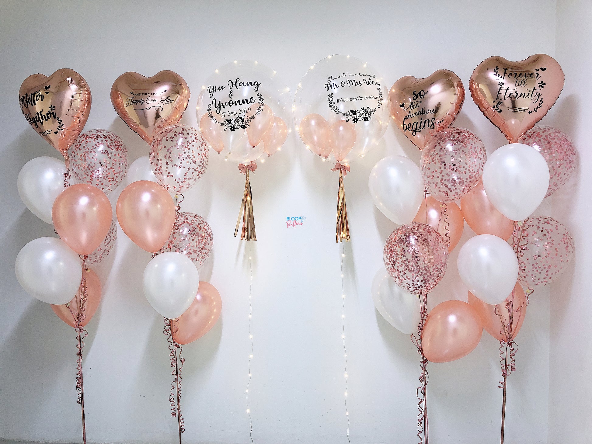 Decorative balloons with heart shapes and text on a white background