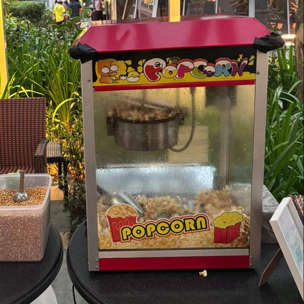 Popcorn machine with popped popcorn on a table outdoors
