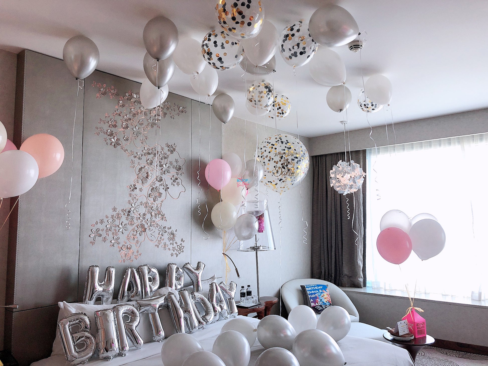 Decorated room with balloons and 'Happy Birthday' sign for a celebration.