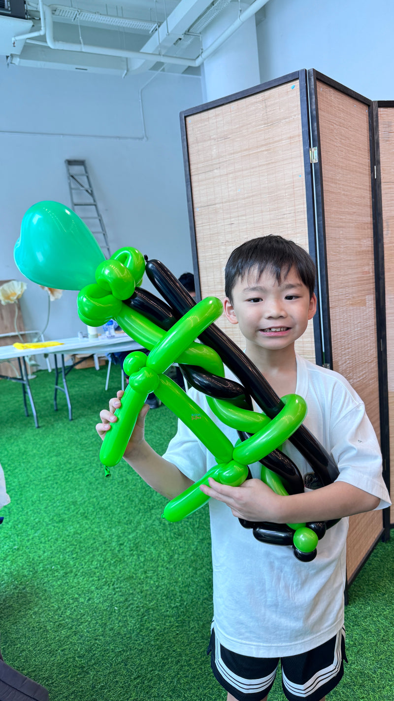 Green and black balloon gun sculpting design for kids party in Singapore by Bloop Balloons