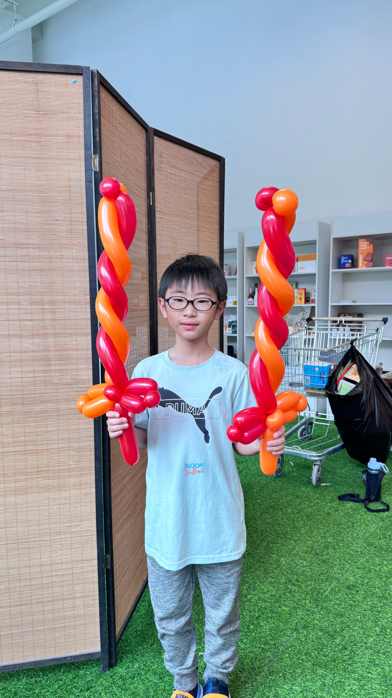 Red and orange balloon sword sculpting design for kids birthday party in Singapore by Bloop Balloons